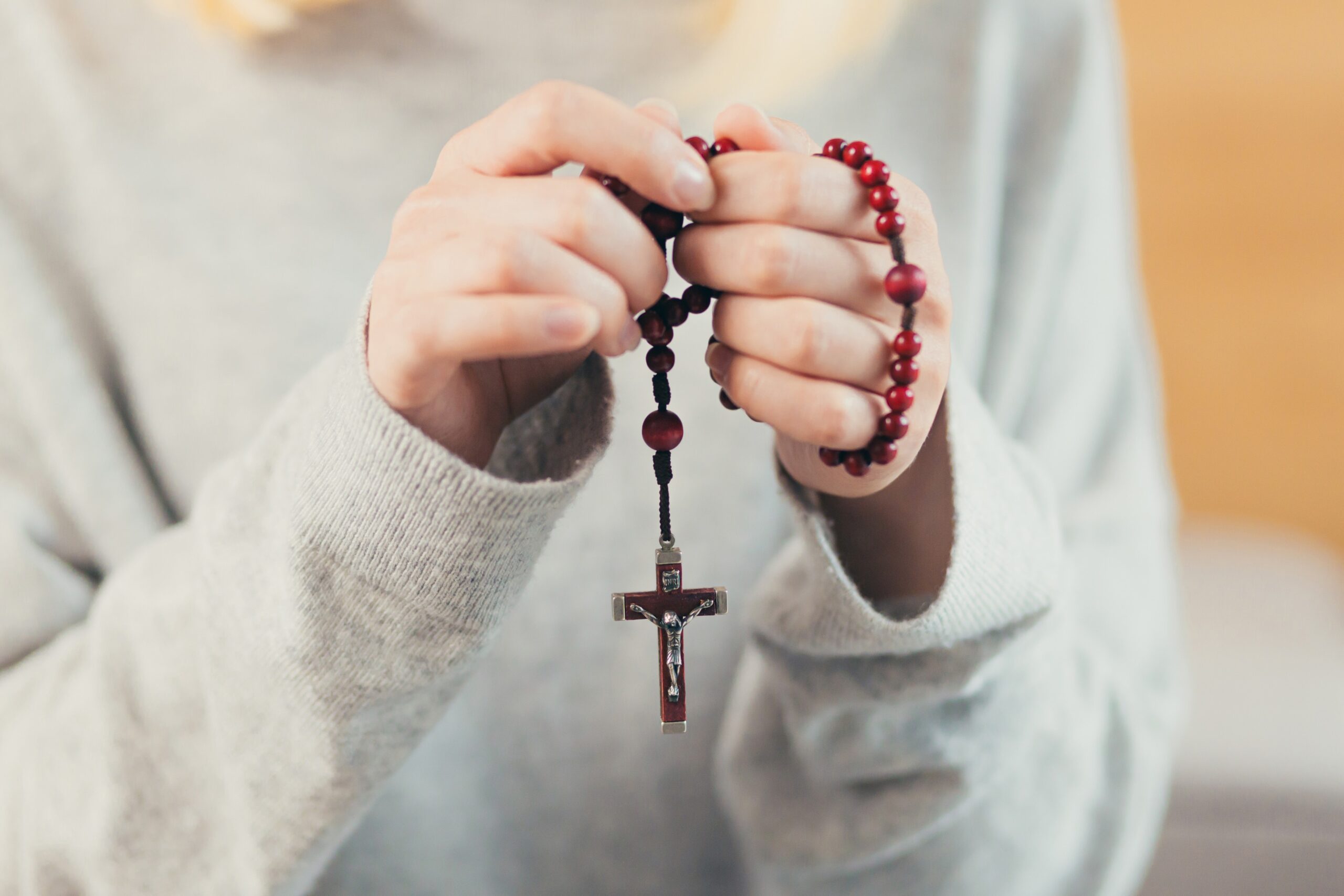 stock photo of woman holding rosary beads