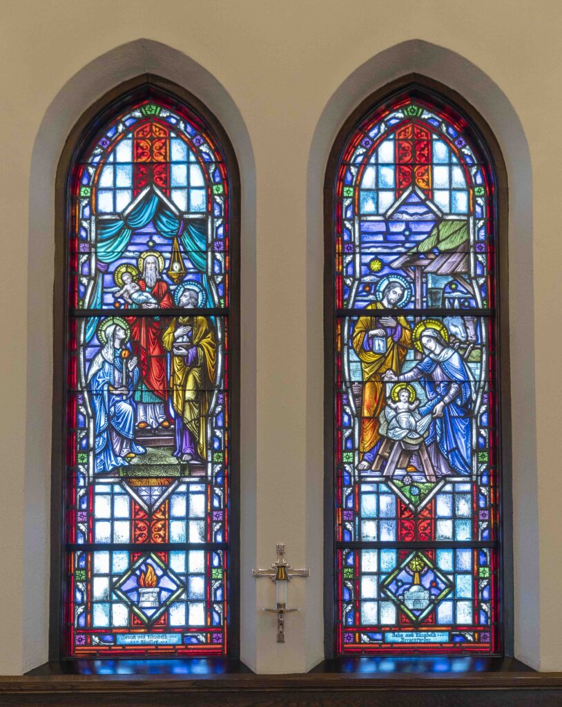 Two stained glass windows. A man holds Jesus, presenting him to the holy family. The second window is the holy family at the nativity. Located at Immaculate Conception Parish in Ravenna. Photo by Brian Keith.