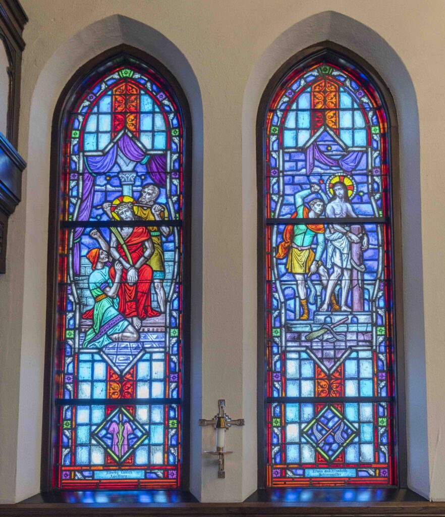 Two stained glass windows. In the window on the left, Jesus is crowned with the crown of thorns. On the right, he is scourged. Located at Immaculate Conception Parish in Ravenna. Photo by Brian Keith.
