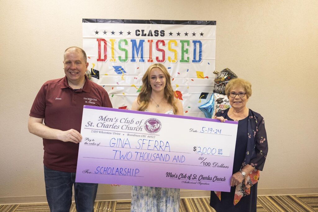 Three people hold a large check