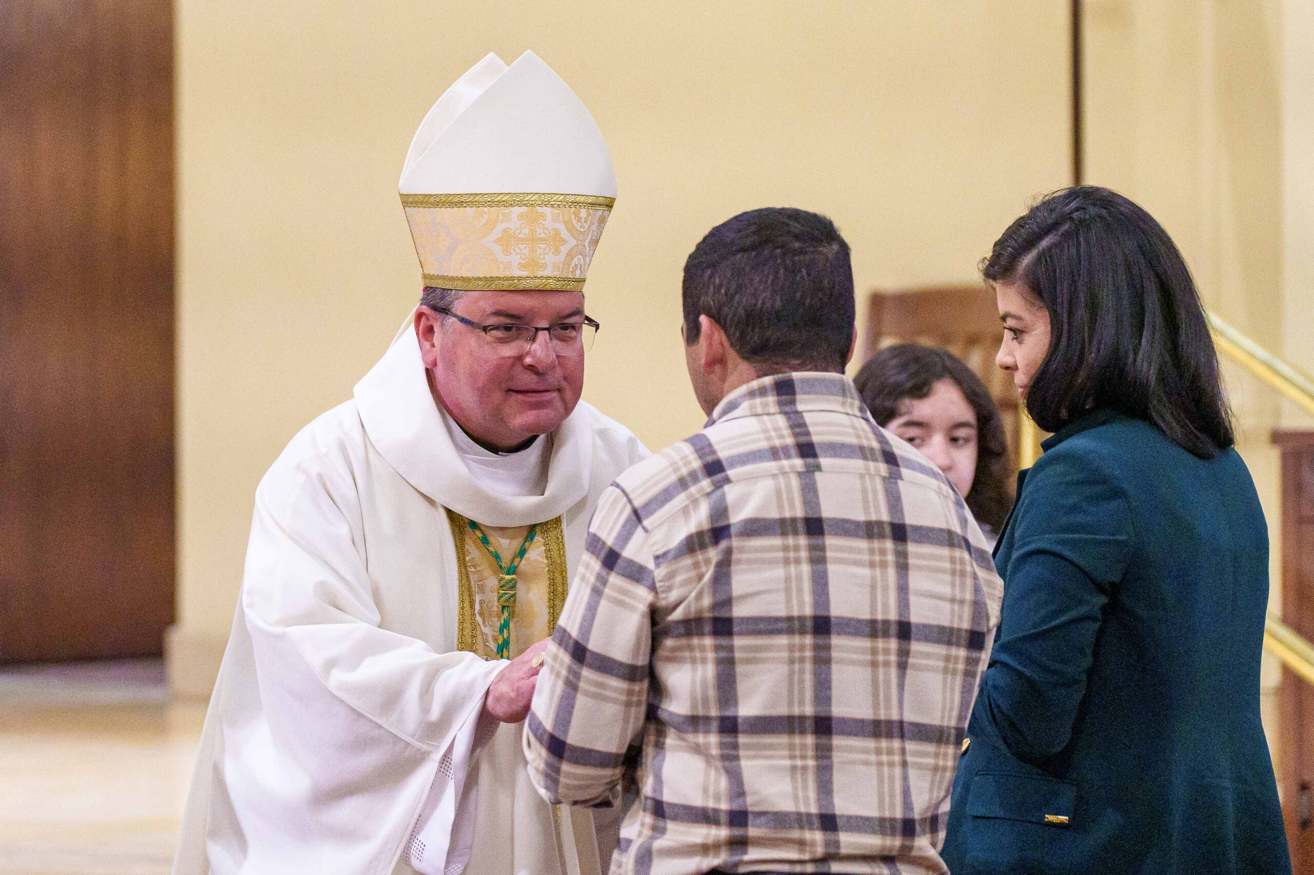 Bishop Bonnar greets young man who brings up the gifts during Mass