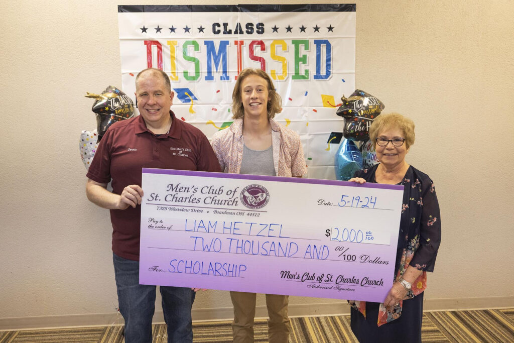 One man and two women hold a large check