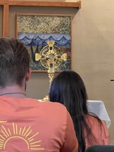 Two people stand in front of a monstrance during Adoration