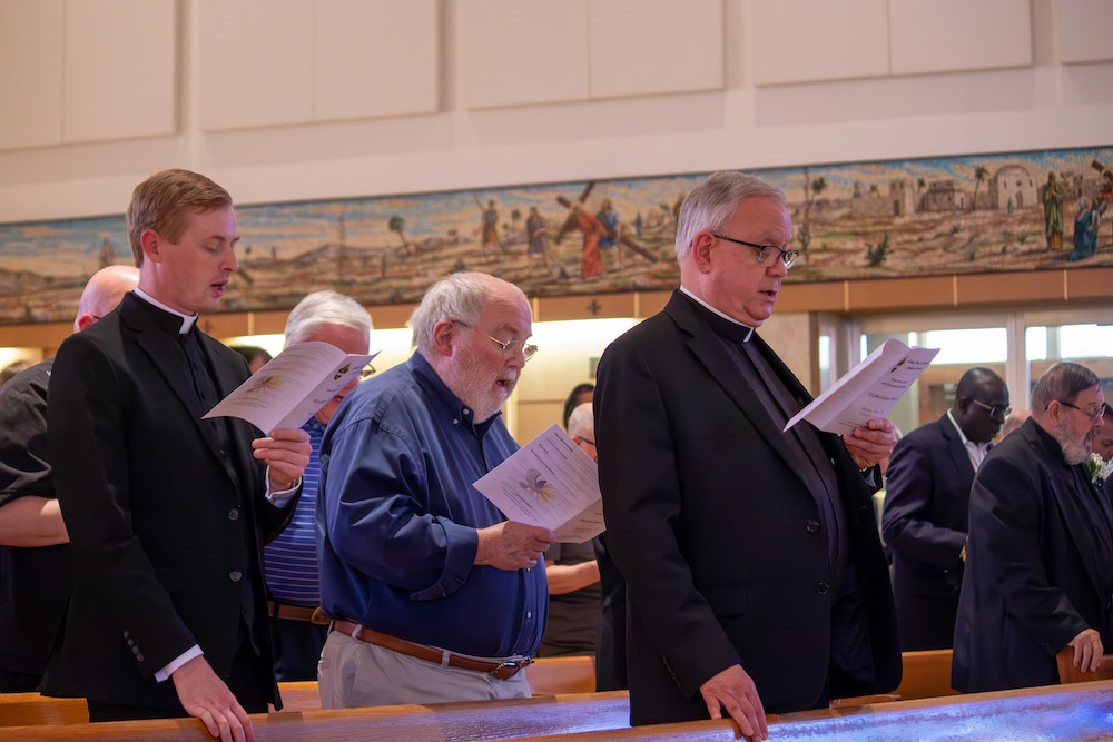 Priests sing from a worship aid at the Priest jubilee Mass on May 8. Photo by Courtney Poullas