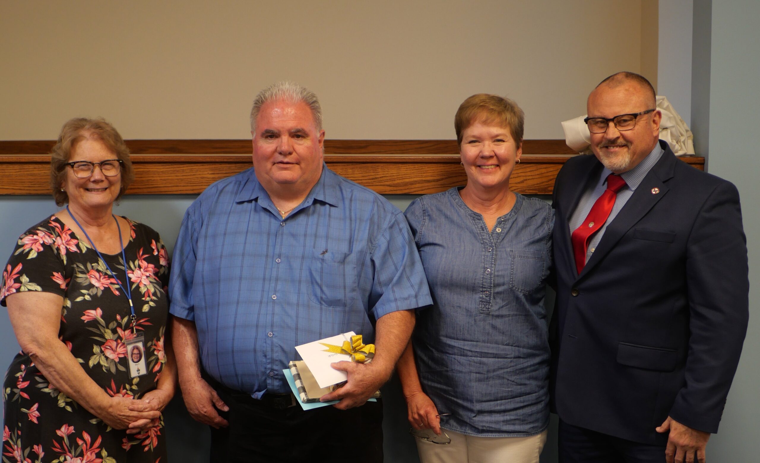 Two men and two women stand with certificates