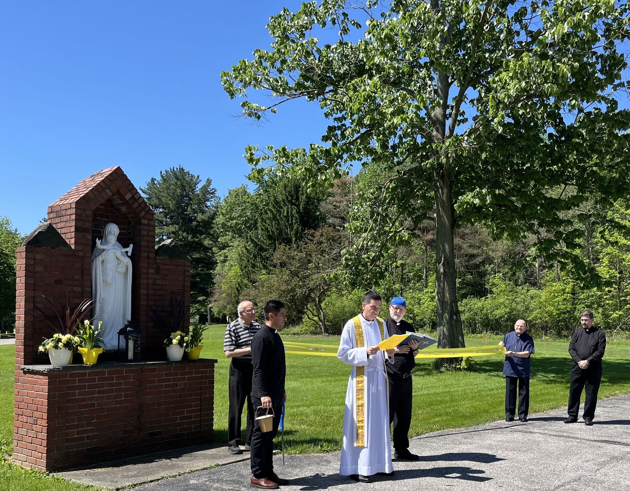 Priests bless the opening of the rosary garden at the Society of St. Paul in Canfield