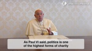 Pope francis, seated at a table, delivering a video message