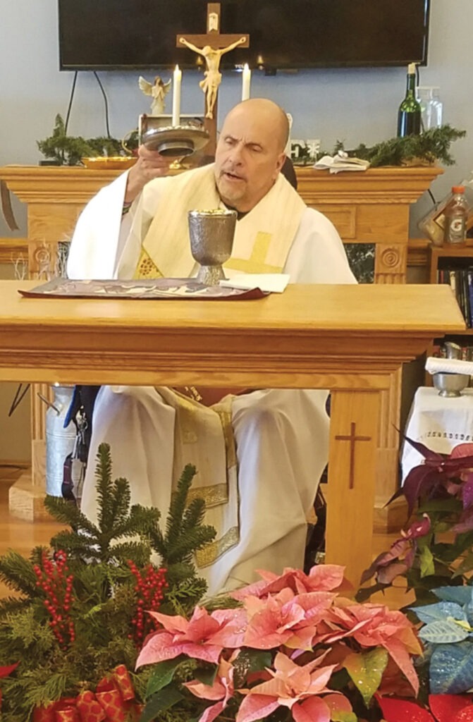 Image of Father Popovich celebrating Christmas Mass in a wheelchair