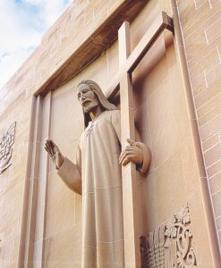 Statue of man holding cross, located at Seminary