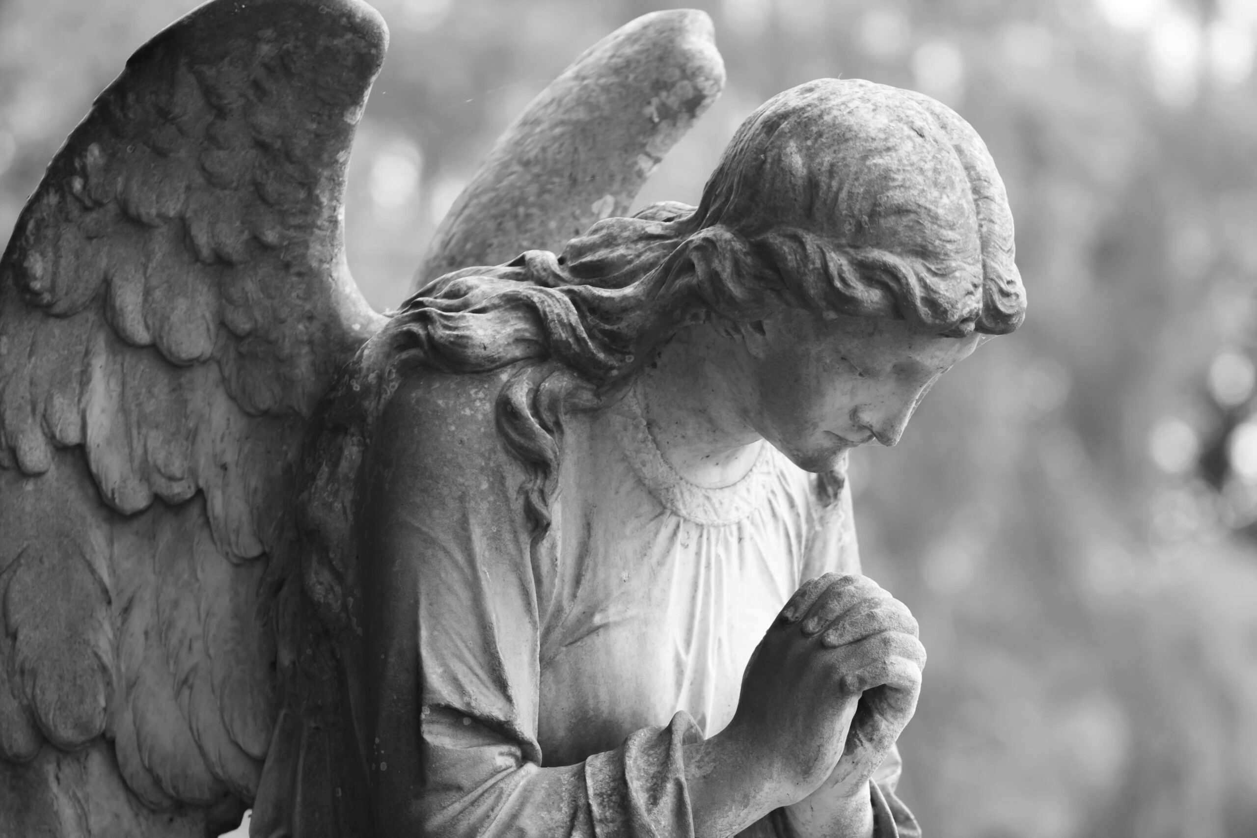 image depicting an angel statue kneeling in prayer