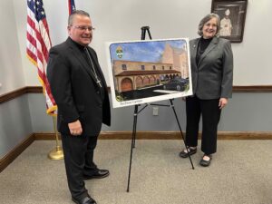 Bishop bonnar and Joan Lawson stand near an image of the archival center