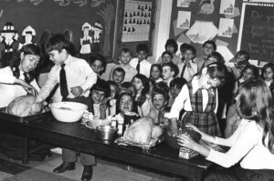 black and white photo showing catholic school chidlren stuffing turkeys