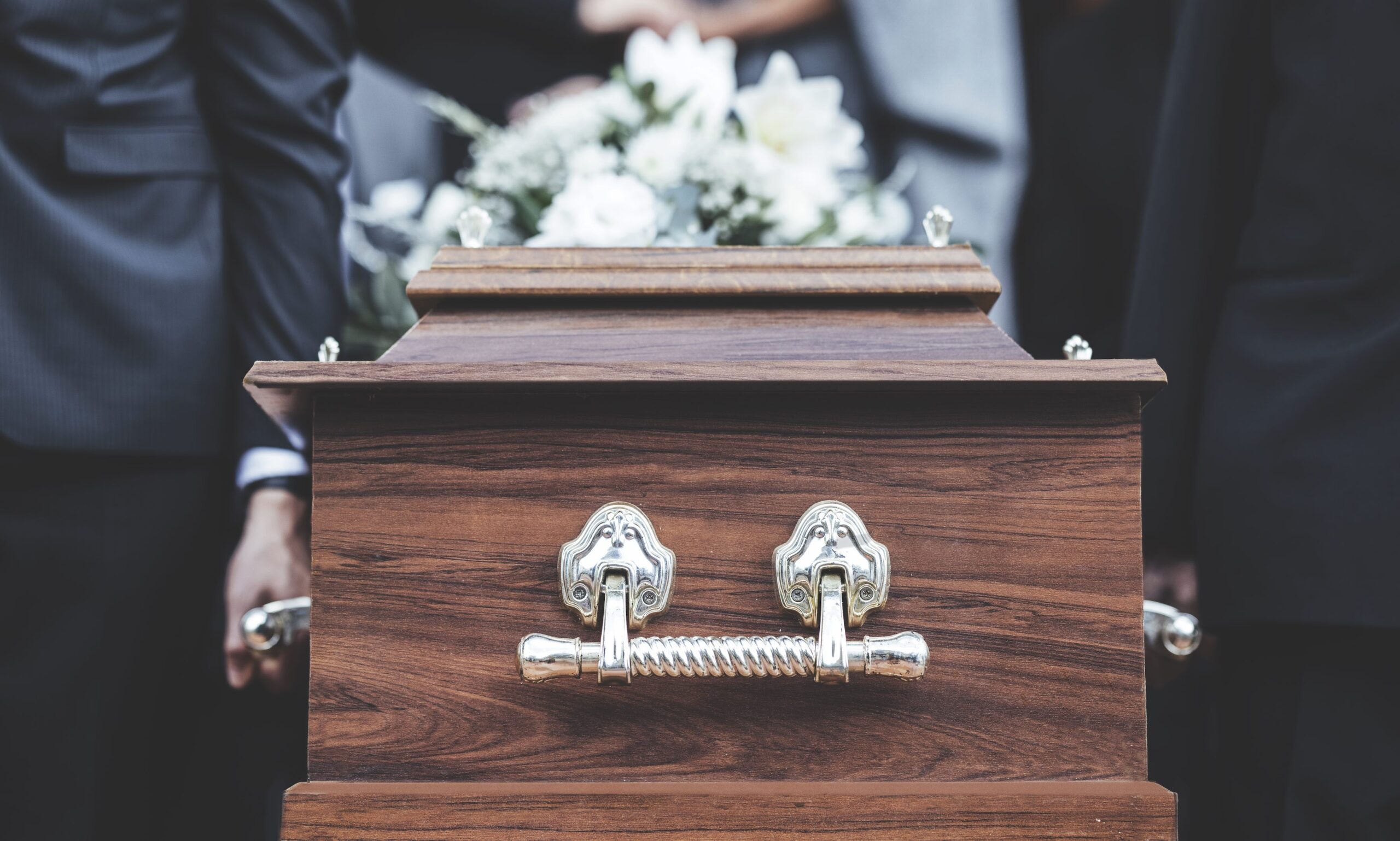 closeup of a coffin being carried by palbears