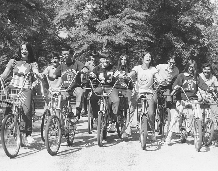 kids ride on bicycles through the park