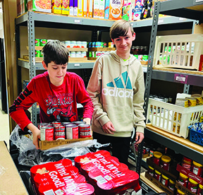 two young boys stock shelves in a food pantry