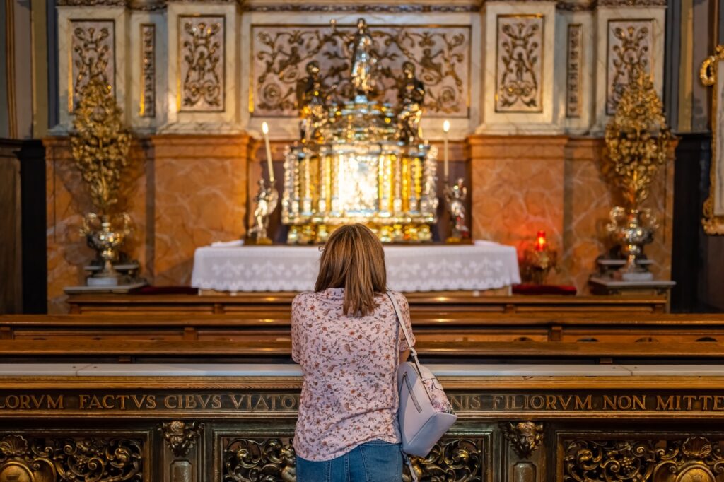 Image of a woman praying before a monstrance