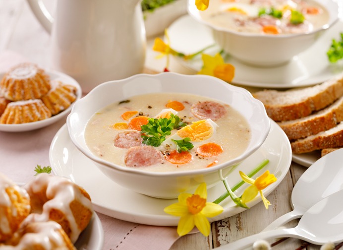 White borscht, polish Easter soup with the addition of white sausage and a hard boiled egg in a ceramic bowl. Traditional Easter dish in Poland