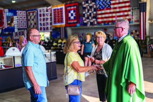 This is a photo from the Columbiana Fair with Father Kevin Peters greeting people who participated in the Fair Mass.