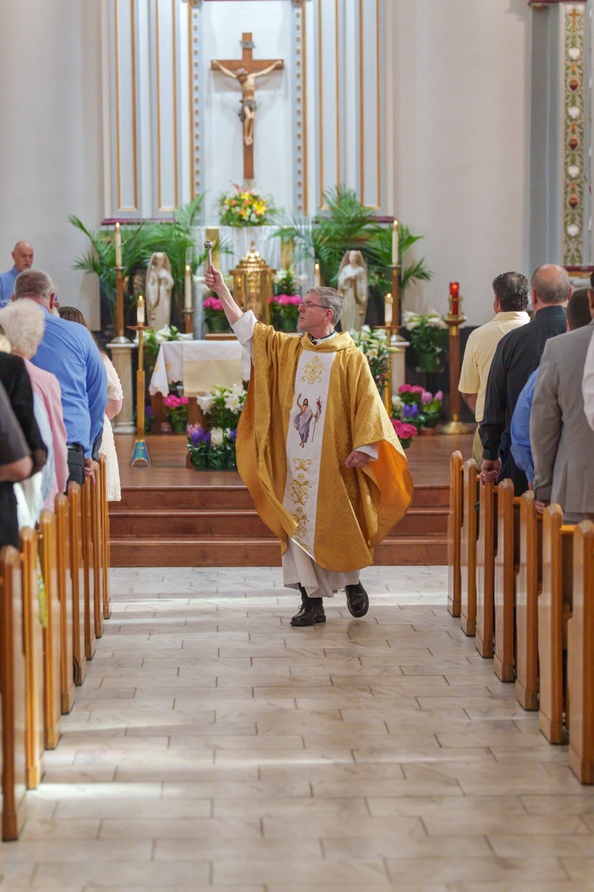 Father performs the sprinkling rite at Holy Trinity Parish in East Liverpool.