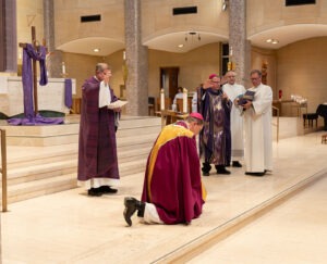 Image of Bishop Keehner kneeling before bishop bonnar, receiving a blessing