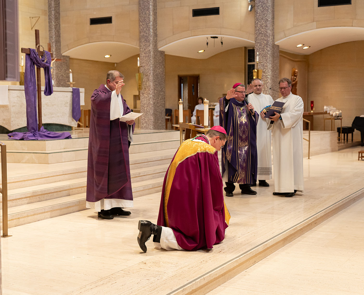 Image of Bishop Keehner kneeling before bishop bonnar, receiving a blessing