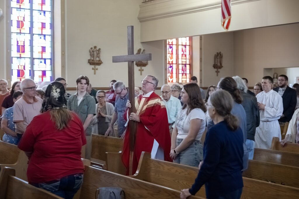 Father processes with the cross at Holy Family in Navarre on Good Friday. Photo by Bob Rossiter.