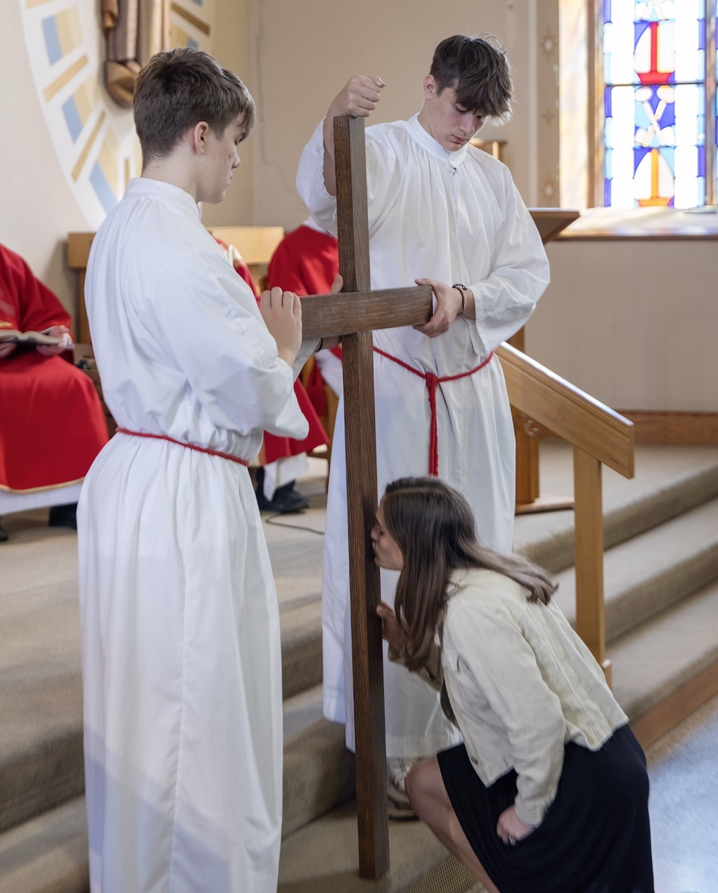 Woman kneels before the cross at Holy Family in Navarre on Good Friday. Photo by Bob Rossiter.