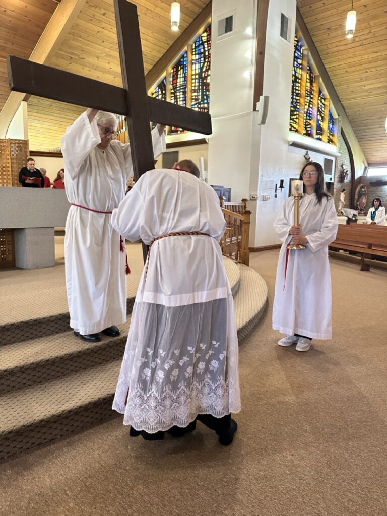 Server kisses the cross at Our Lady of Peace Parish in Ashtabula during Good Friday. Photo by Marilou McClimans.