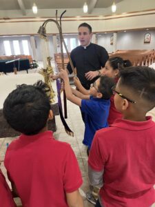 Image of a priest training altar servers in Sioux City, Iowa