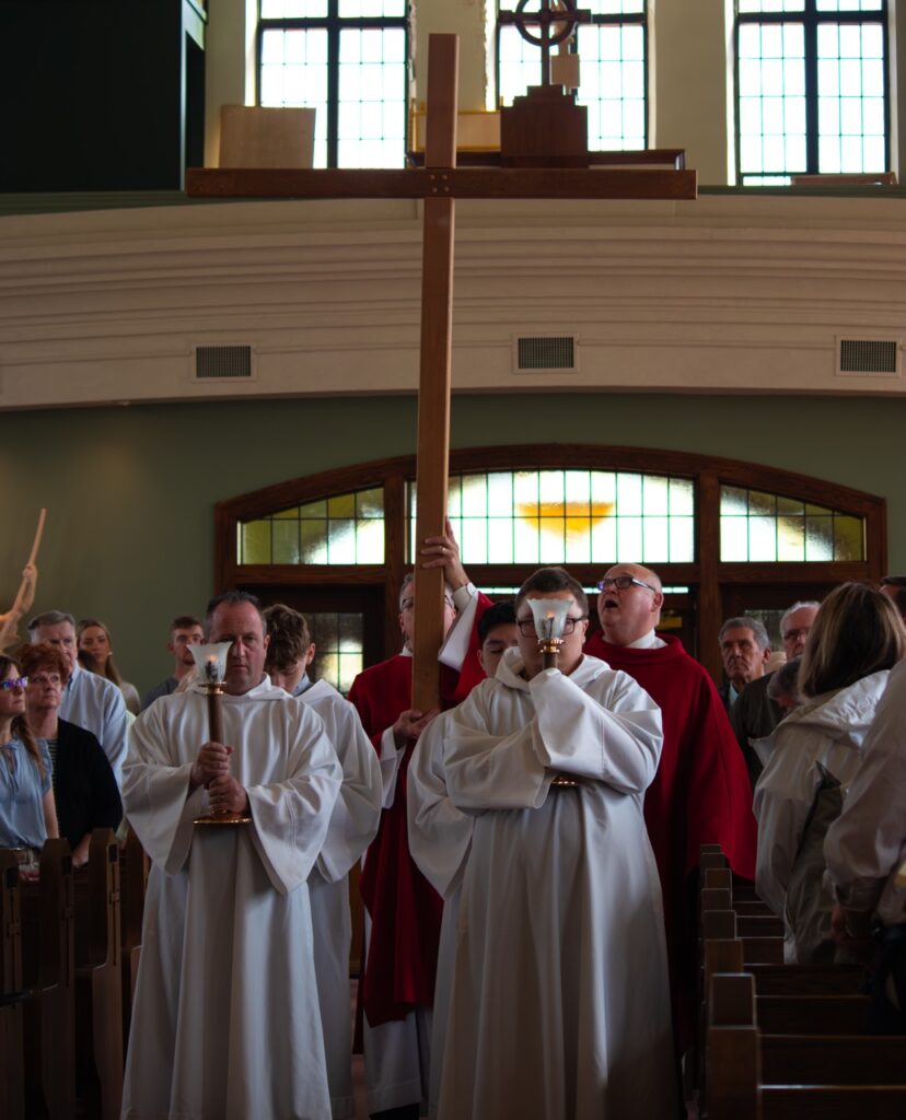 Father processes with cross at St. Brendan Parish on Holy Friday. Photo by Courtney Poullas.