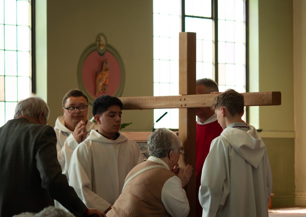 Woman kisses the cross at St. Brendan Parish on Holy Friday. Photo by Courtney Poullas.