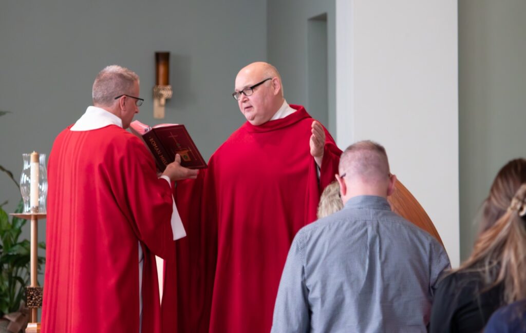 Father reads from sacred text at St. Brendan Parish on Holy Friday. Photo by Courtney Poullas.