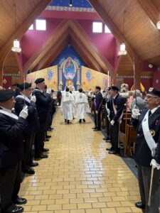 Clergy walk in procession, past Knights of Columbus, at the Assumption pilgrimage in North Jackson.