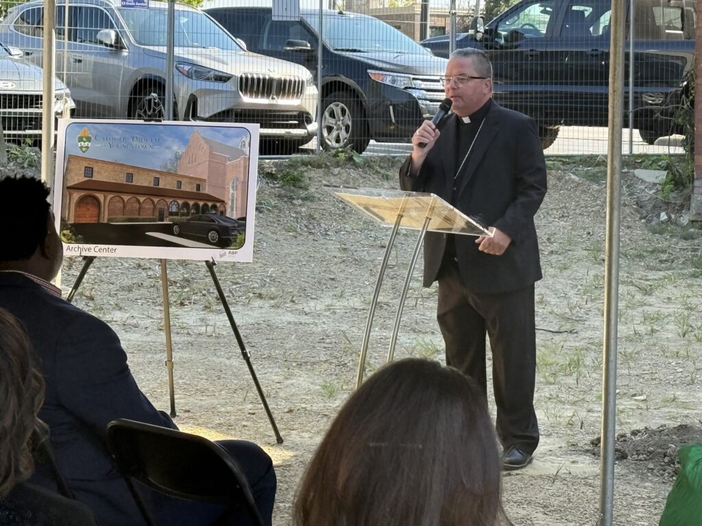 Bishop speaks at a podium at the groundbreaking for the new archival center