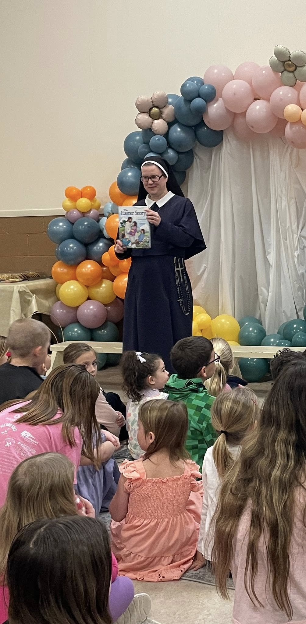 Photo of nun reading an Easter story to children.