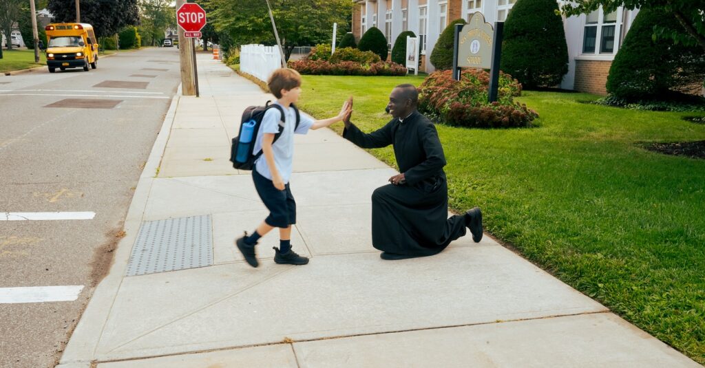 SS Philip and James student high fives a priest