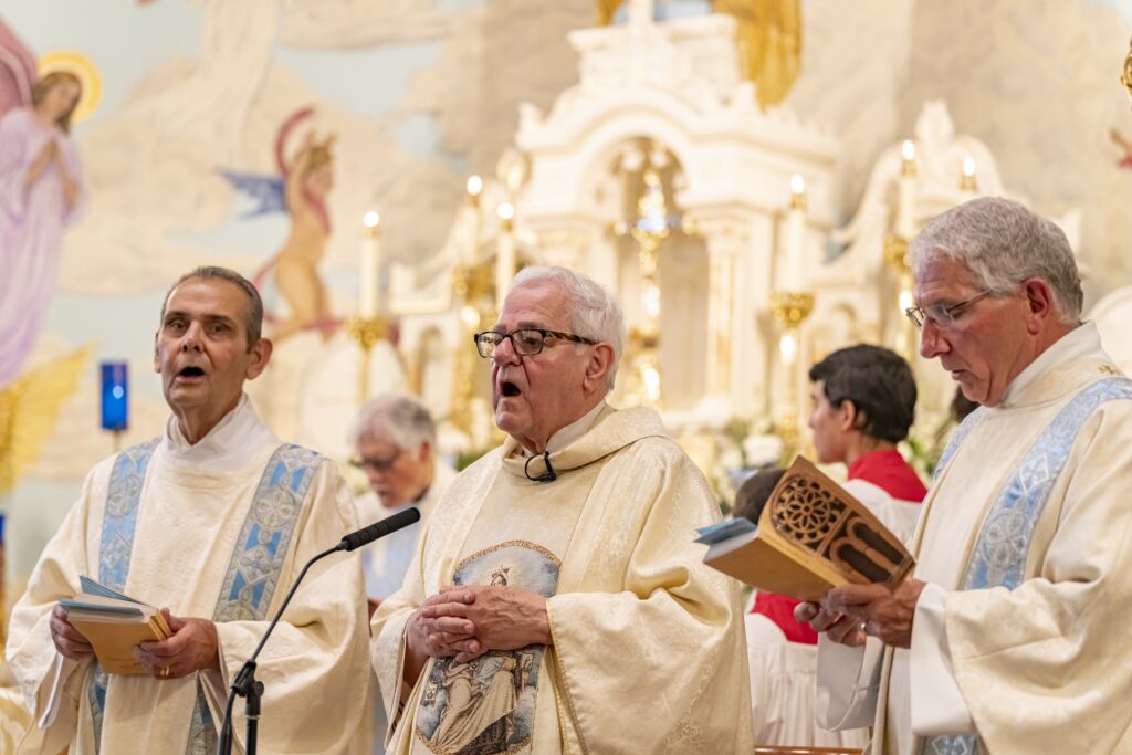 Monsignor Cariglio speaks into a mic